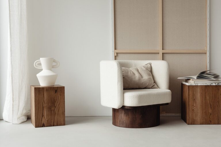 Natural light over an upholstered armchair with an open book on a wooden table, cube shaped - an example of wellness-focused design.