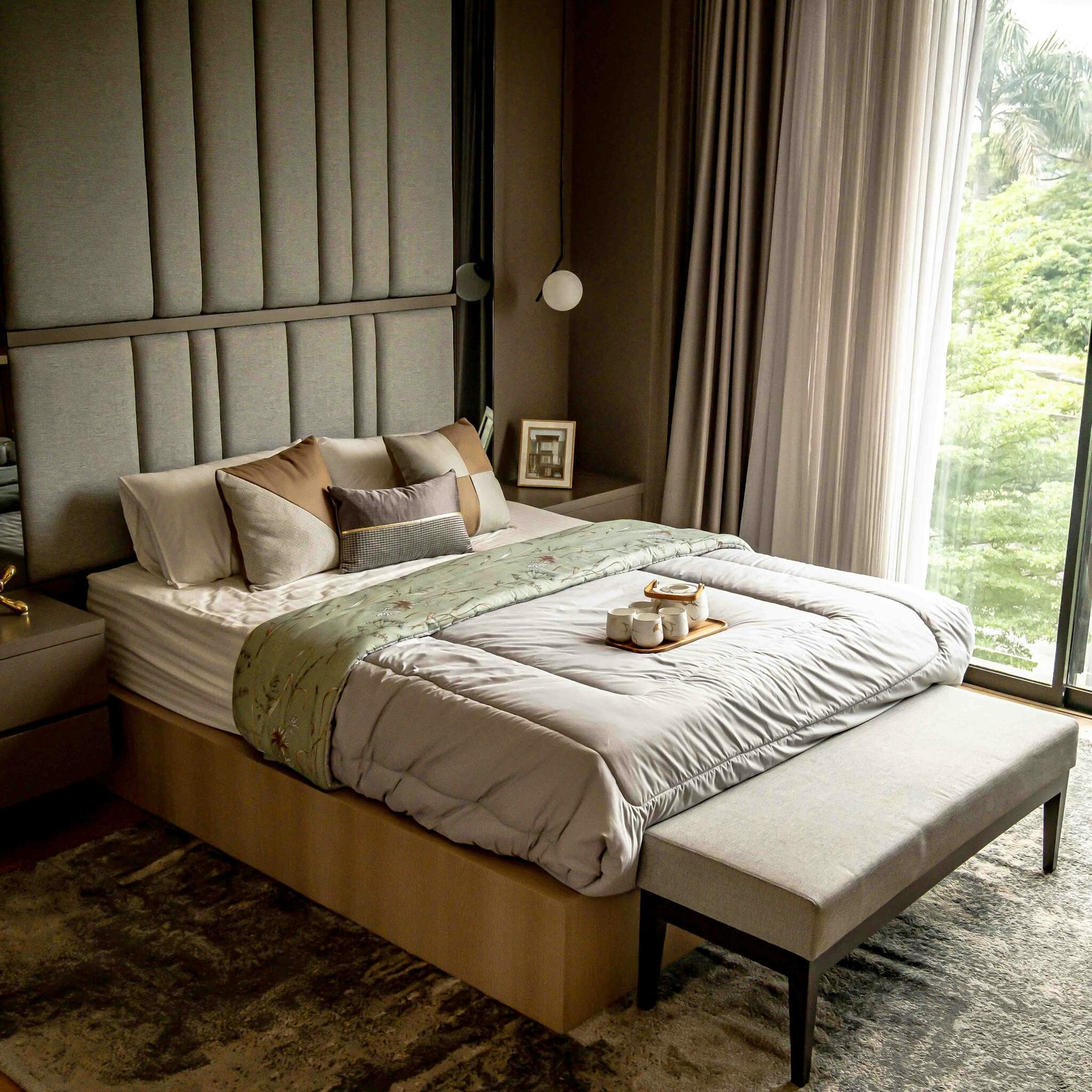 Cozy and stylish bedroom with elegant decor and a nature view from the window.