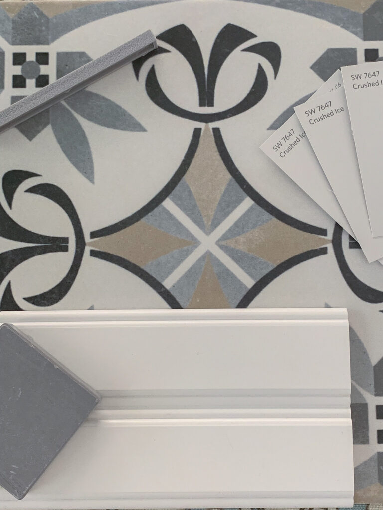 Material samples for laundry room renovation including countertop, cabinet, patterned tile, paint color, and grout.