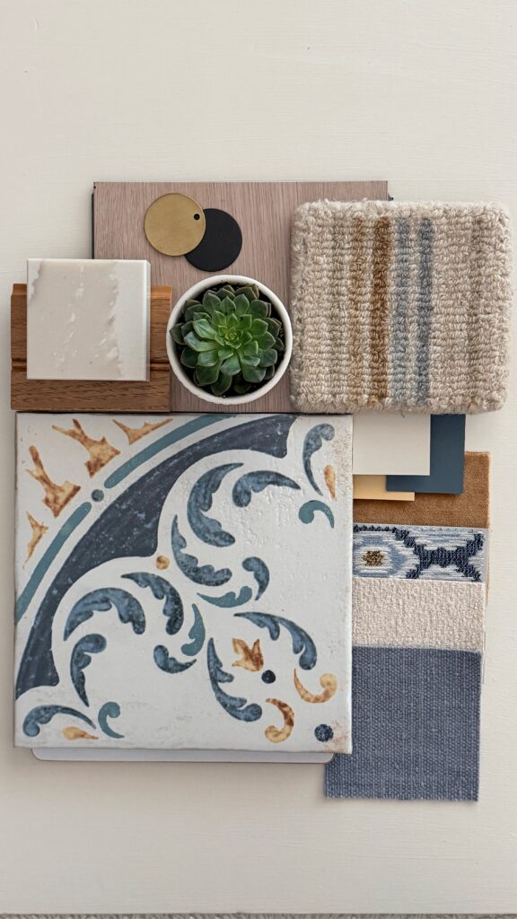 Interior design material palette featuring Mediterranean-inspired decorative tile, creamy stone, warm wood, woven textiles, brushed brass and matte black finishes, and a succulent.