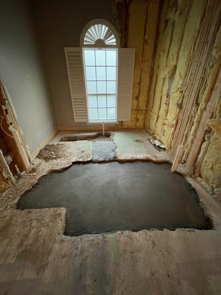 Concrete slab cut and plumbing relocated beneath the primary bathroom to create a larger walk-in shower and improve the overall room layout.