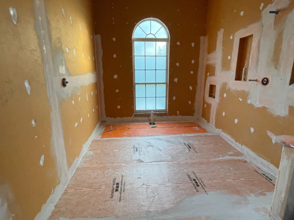 Schluter®-KERDI waterproofing membrane installed in the new walk-in shower before tile installation, providing long-term protection against moisture intrusion in the primary bathroom remodel.